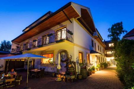 Außenansicht Haus mit Terrasse und Innenhof abends