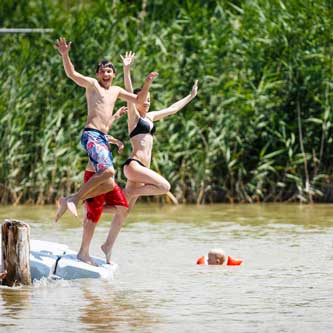 Kinder springen in den See