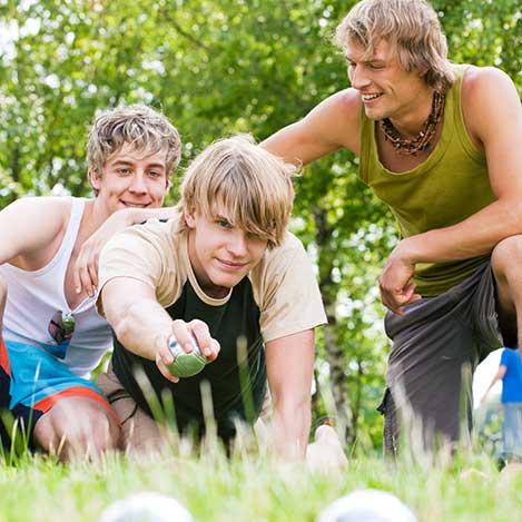 Drei Männer spielen Boule in der Wiese