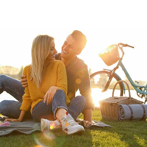 Mann und Frau beim Picknick mit Fahrrad im Hintergrund im Mörbisch am See Mann und Frau beim Picknick mit Fahrrad im Hintergrund